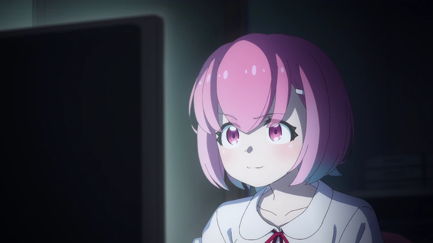 Kurumi, de cabelo rosa, diante de um monitor em um quarto escuro.