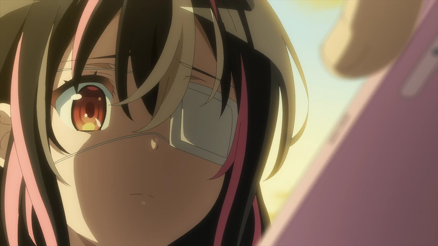 Yui Saikawa olha para um celular sob a luz dourada do fim de tarde.